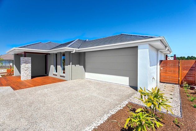 Exposed aggregate driveway with a mix of warm-toned stones leading to a modern Sydney home